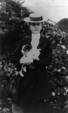 Alice Roosevelt in riding clothes, with dog, c1902 June 17. Creator: Frances Benjamin Johnston