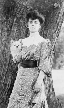 Alice Roosevelt Longworth, three-quarter length portrait, standing in front of tree...dog, c1902. Creator: Frances Benjamin Johnston