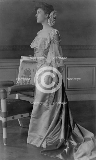 Alice Roosevelt Longworth, full-length portrait, standing next to chair, facing left, 1903. Creator: Frances Benjamin Johnston.