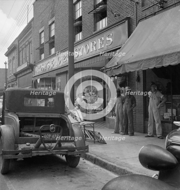 Appliqued embroideries for sale on street in front of ten cent..., Siler City, North Carolina, 1939. Creator: Dorothea Lange.