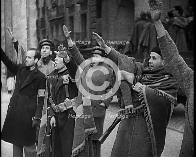Armed Men and Civilians Making Fascist Salutes in a Street in Madrid, All Dressed in Thick..., 1939. Creator: British Pathe Ltd.