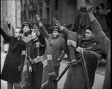 Armed Men and Civilians Making Fascist Salutes in a Street in Madrid, All Dressed in Thick..., 1939. Creator: British Pathe Ltd