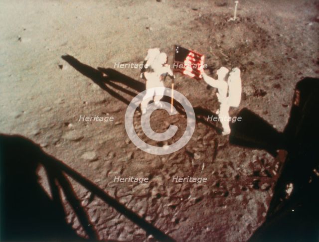 Armstrong and Aldrin unfurl the US flag on the moon, 1969.  Creator: Unknown.