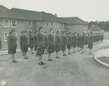 Army nurses standing at attention in front of their barracks and being inspected by..., 1939 - 1945. Creator: Unknown