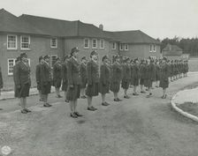 Army nurses standing at attention in front of their barracks and being inspected by..., 1939 - 1945. Creator: Unknown