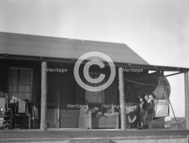 Arnold Genthe and two women friends seated on a swing on the porch of his...New York, c1911-c1942. Creator: Arnold Genthe.