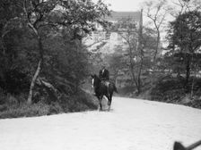 Arnold Genthe riding Chesty, between 1911 and 1936. Creator: Arnold Genthe