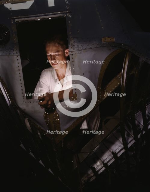 As an NYA trainee working inside the nose of a PBY, Elmer J. Pace...Corpus Christi, Texas, 1942. Creator: Howard Hollem.