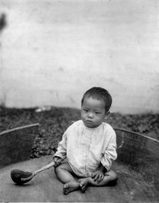 Asian(?) baby seated holding spoon or ladle, World's Columbian Exposition, Chicago, Ill., 1891 or 92 Creator: Frances Benjamin Johnston