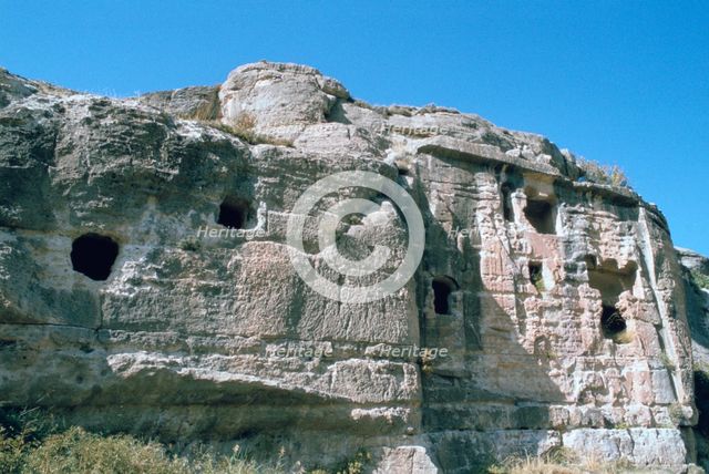 Assyrian rock reliefs pitted by Chr hermit caves, Bavian, Iraq, 1977.