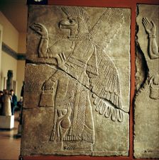 Assyrian relief of Winged genie carrying a cedar-cone