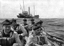 At Sea: The coastguard: boarding crew going aboard a suspect trawler..., 1917. Creator: Unknown