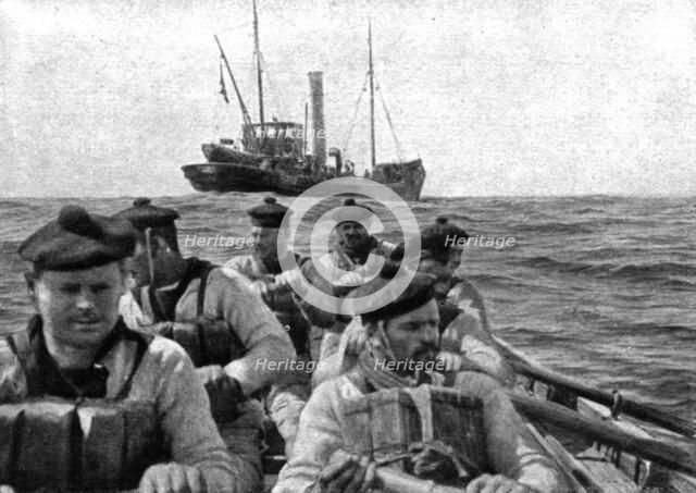 At Sea: The coastguard: boarding crew going aboard a suspect trawler..., 1917. Creator: Unknown.