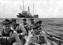 At Sea: The coastguard: boarding crew going aboard a suspect trawler..., 1917. Creator: Unknown