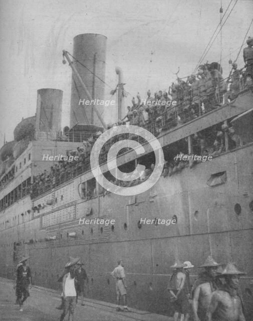 'At Singapore Indian troops arrive to take part in the defence of the great fortress-port.', 1941.  Artist: Unknown.