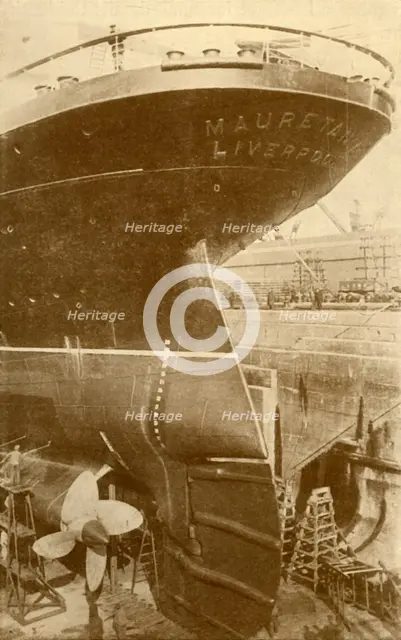 'At Work on the Stern of the "Mauretania", in Dry Dock', c1930. Creator: Unknown.