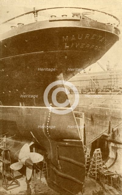'At Work on the Stern of the "Mauretania", in Dry Dock', c1930. Creator: Unknown.