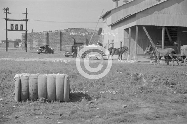 At the cotton gin, Cotton gin and wagons, Hale County, Alabama, 1936. Creator: Walker Evans.