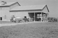 At the cotton gin, Cotton gin and wagons, Hale County, Alabama, 1936. Creator: Walker Evans