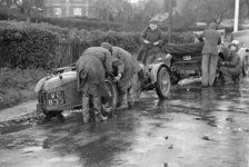 Attaching snow chains to JE Lancaster's Riley Brooklands during the Inter-Varsity Trial, 1930. Artist: Bill Brunell
