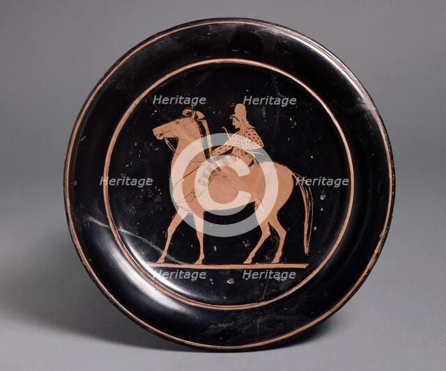 Attic red-figure plate showing a mounted archer in oriental costume in the interior, inscribeld Mil Artists: Unknown, Paseas.