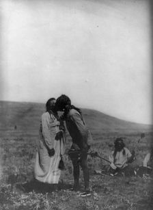 Atsina crazy dance-[A dancer kisses the grandfather], c1908. Creator: Edward Sheriff Curtis