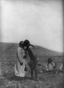 Atsina crazy dance-[A dancer kisses the grandfather], c1908. Creator: Edward Sheriff Curtis