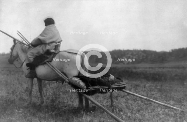 Atsina Indian on horse pulling travois, c1908. Creator: Edward Sheriff Curtis.
