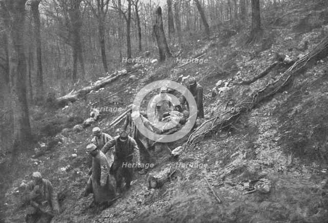 'Aux Eparges; Le transport des blesses sur les pentes boisees des Eparges', 1915 (1924). Creator: Unknown.