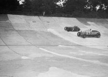 Austin 747 cc works racer and another car on the Members Banking at Brooklands. Artist: Bill Brunell