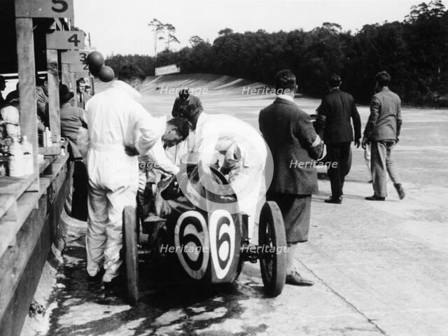 Austin by the pit wall, 500 Mile Race, Brooklands, Surrey, (1931?). Artist: Unknown