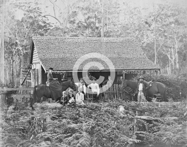 Australian wooden slab hut with large unknown family outside, c1900s. Creator: Robert Augustus Henry L'Estrange.