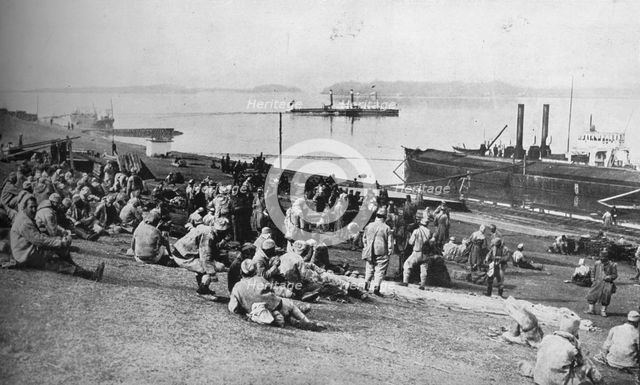 ''Austrian prisoners taken by Serbians resting at mid-day on the banks of the Danube', 1915.  Artist: Unknown.