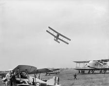Avro 504 biplane flying very low over parked aircraft at the RAF Pageant, Hendon, London, 1927. Artist: Aerofilms