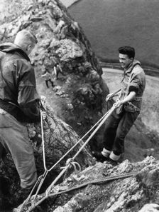 Boy about to start descent of rock face, Outward Bound School, Eskdale, Cumbria,1950