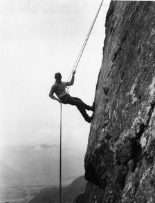 Boy abseiling down rock face, Outward Bound School, Eskdale, Cumbria, 1950