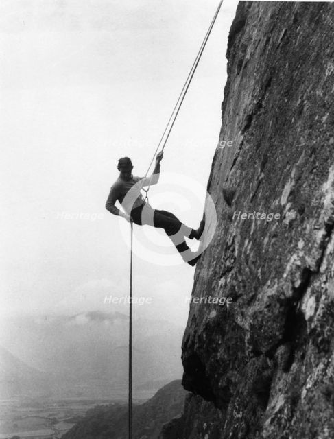 Boy abseiling down rock face, Outward Bound School, Eskdale, Cumbria, 1950. Artist: Unknown