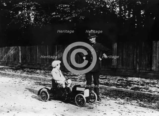 Boy in 1908 Mercedes pedal car. Artist: Unknown
