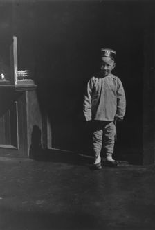 Boy in doorway of lamp store, Chinatown, San Francisco, between 1896 and 1906. Creator: Arnold Genthe