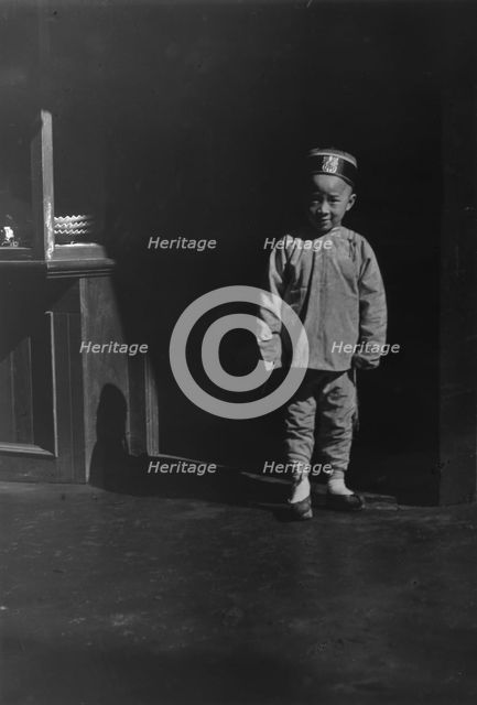 Boy in doorway of lamp store, Chinatown, San Francisco, between 1896 and 1906. Creator: Arnold Genthe.
