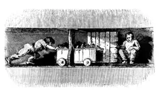 Boy pushing a truck loaded with coal from the coal face to the bottom of the pit shaft, c1848. Creator: Unknown