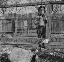 Boy playing in the backyard of his home, Washington (southwest section), D.C., 1942. Creator: Gordon Parks