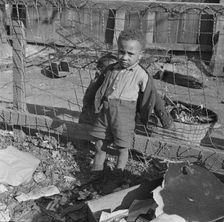 Boy playing in the backyard of his home, Washington (southwest section), D.C., 1942. Creator: Gordon Parks