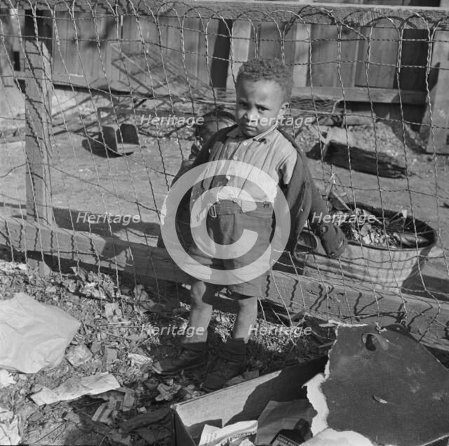 Boy playing in the backyard of his home, Washington (southwest section), D.C., 1942. Creator: Gordon Parks.