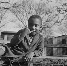 Boy playing on a fence, Washington (southwest section), D.C., 1942. Creator: Gordon Parks