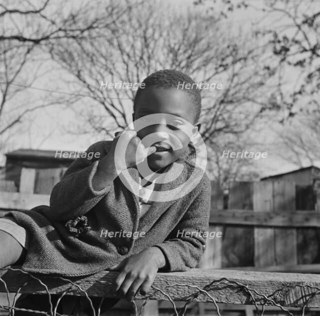 Boy playing on a fence, Washington (southwest section), D.C., 1942. Creator: Gordon Parks.