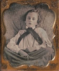 Boy Seated Cross-legged, Partially Covered by Blanket, Leaning Against Cushion, 1850s. Creator: Unknown