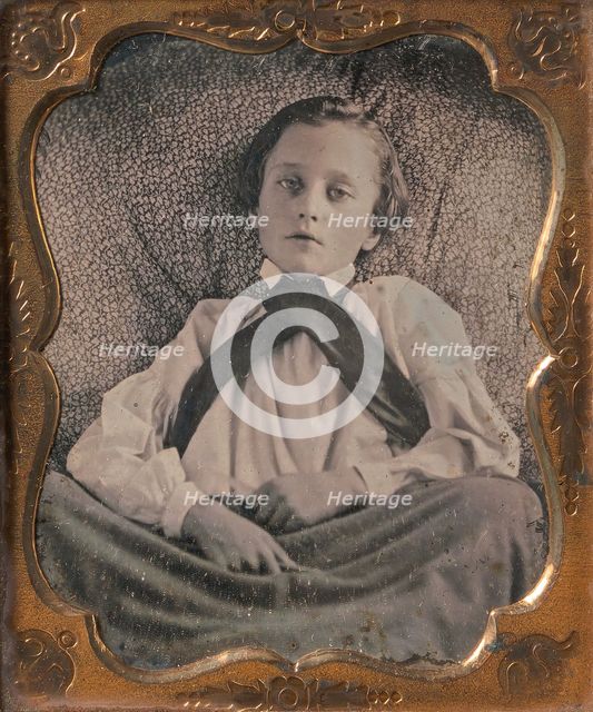 Boy Seated Cross-legged, Partially Covered by Blanket, Leaning Against Cushion, 1850s. Creator: Unknown.