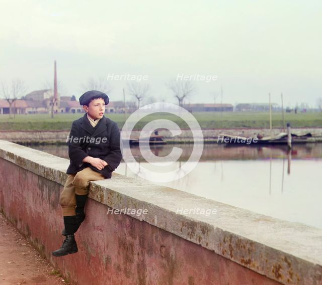 Boy sitting on sea wall, between 1905 and 1915.  Creator: Sergey Mikhaylovich Prokudin-Gorsky.