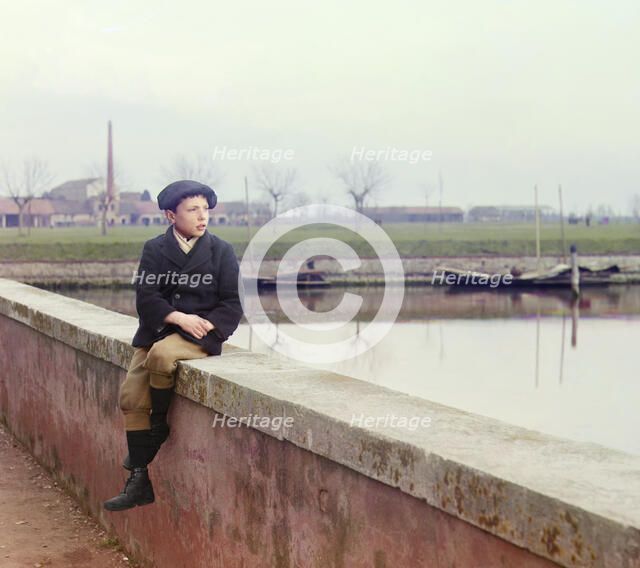 Boy sitting on sea wall, between 1905 and 1915.  Creator: Sergey Mikhaylovich Prokudin-Gorsky.